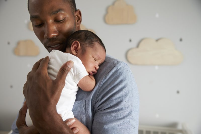 Father-Holding-Newborn Baby Son In Nursery Parenting